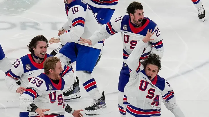 United States' Jack Hughes (86), right, celebrates with teammates after scoring the game winning goal against Canada in sudden death overtime during the men's ice hockey gold medal game at the 2026 Winter Olympics, in Milan, Italy, Sunday, Feb. 22, 2026.  (AP Photo/Luca Bruno)