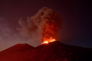 FILE PHOTO: Volcanic material and fumes rise from Mount Etna during an eruption under a starry sky in Sicily, Italy, July 30, 2026. REUTERS/Giuseppe Di Stefano/File Photo